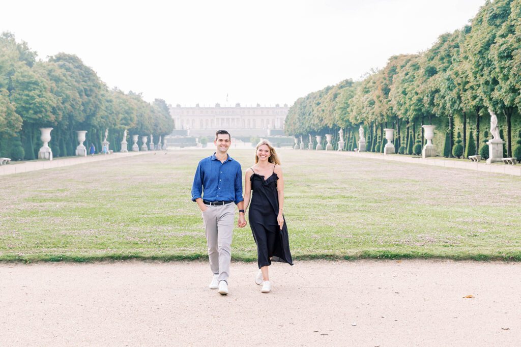 happy couple walking hand in hand after getting engaged at versailles