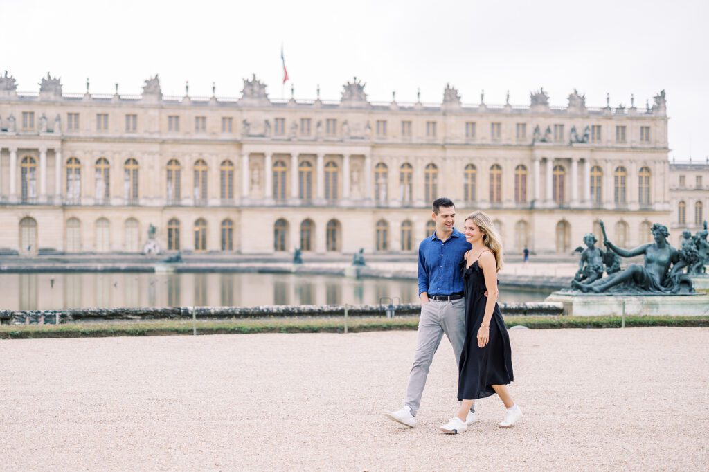 a newly engaged couple walking in the gardens of versailles