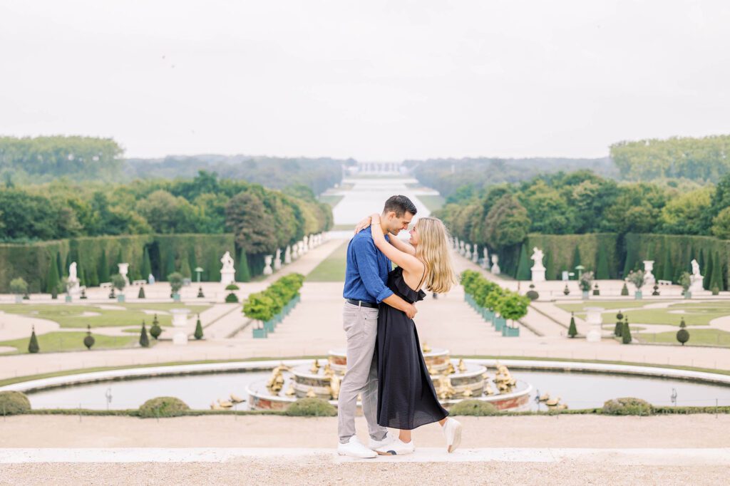 romantic portrait of a couple at the palace of versailles with the gardens in the background